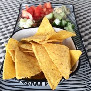 Serving of tortilla chips with salsas. 